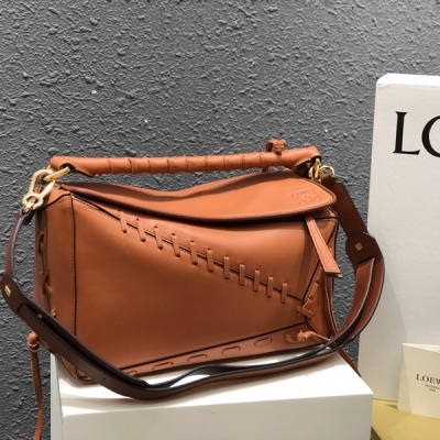 Loewe羅意威 puzzle 採用進口西班牙小牛皮 純手工拼接以流行的編織元素 織帶的纏繞勾勒出浪漫風貌 為包身同時賦於質感與動感 呈現出獨樹一幟的魅力 紡織內襯 Size:中號29*18*12 型號：6981土黃色／