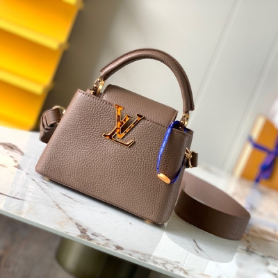 LOUIS VUITTON LV 路易威登 特級精品原廠皮M58718灰褐金色貝殼扣 本款Capucines Mini 手袋采選全粒面 Taurillon 牛皮革，以牛皮革點綴貝殼V扣，為衣櫥增添個性