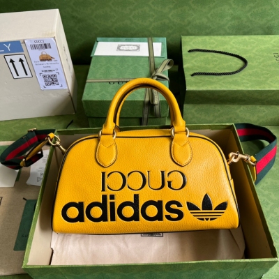 GUCCI古馳 adidas x Gucci聯名系列迷你旅行包，作為adidas x Gucci聯名系列之一，這款迷你旅行包飾有“Gucci adidas”和Trefoil印花。adidas和Gucci大膽探索聯名系列，織帶和GG字母交織圖