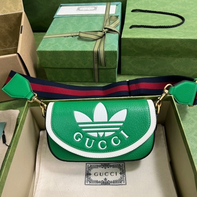 GUCCI古馳 adidas x Gucci聯名系列迷你手袋。adidas和Gucci再啟聯名合作新篇章，繼續以織帶元素和GG字母交織圖案巧妙搭配白色三條紋和三葉草徽標。該系列靈感源自創作總監80年代和90年代的美好回憶，融匯兩個品牌豐富悠